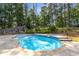 An in-ground pool surrounded by lush greenery offers a private and serene backyard retreat at 825 Yosemite Dr, Suwanee, GA 30024