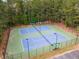 Aerial view showcases community tennis courts with nets, lighting and benches at 825 Yosemite Dr, Suwanee, GA 30024