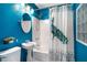 Bathroom with bright blue walls, pedestal sink, glass block window, and decorative peacock shower curtain at 118 Waverly Way, Atlanta, GA 30307