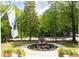 View of a beautifully landscaped home with a circular garden and mature trees at 118 Waverly Way, Atlanta, GA 30307