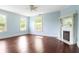 Bright living room boasts hardwood floors, neutral paint, many windows, and a decorative fireplace at 118 Waverly Way, Atlanta, GA 30307