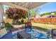 Relaxing covered patio with cushioned seating, blue rug, and manicured lawn in fenced backyard at 11865 Brisbane Dr, Alpharetta, GA 30009