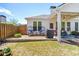 Well-kept backyard featuring a covered patio, egg chairs, lush lawn, and privacy fence at 11865 Brisbane Dr, Alpharetta, GA 30009