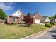 Attractive brick home with manicured lawn, colorful plants, and two-car garage on a sunny day at 11865 Brisbane Dr, Alpharetta, GA 30009