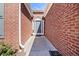 Close-up of a brick house entrance with a gray front door and surrounding trim and greenery at 11865 Brisbane Dr, Alpharetta, GA 30009