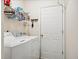 Functional laundry room with white washer, dryer, and wire shelving for organized storage at 11865 Brisbane Dr, Alpharetta, GA 30009