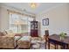 Comfortable living room with a large window, sofa, ottoman, decorative rug and a bookcase in neutral tones at 11865 Brisbane Dr, Alpharetta, GA 30009