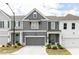 Charming townhome with a gray facade, white trim, well-manicured lawn, and a two-car garage at 1717 Cosette Ln, Kennesaw, GA 30152
