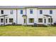 Townhome backyard with green lawn, HVAC units, and back entrances at 209 Starr Cir, Stockbridge, GA 30281