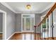 Elegant foyer showcases wood floors, decorative glass front door, staircase with wooden handrail and wrought iron spindles at 395 Clubfield Dr, Roswell, GA 30075