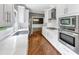 Well-appointed kitchen features stainless appliances, sleek white cabinets, and an open layout to the dining area at 395 Clubfield Dr, Roswell, GA 30075
