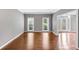 Bright living room featuring hardwood floors, large windows offering natural light, and neutral paint provides a calming space at 395 Clubfield Dr, Roswell, GA 30075