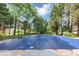 Outdoor view of inground pool with pool cover in backyard with mature trees and bright sky at 395 Clubfield Dr, Roswell, GA 30075