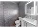 Modern powder room with mirrored tiles, illuminated mirror, and marble vanity at 395 Clubfield Dr, Roswell, GA 30075