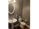Powder room with pedestal sink and toilet featuring neutral colors and wood look flooring at 106 Trailside Way, Hiram, GA 30141