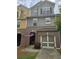 Charming townhome with brick facade, an attached garage, an American flag, and a well-maintained lawn at 106 Trailside Way, Hiram, GA 30141