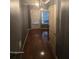 Hallway with dark wooden flooring and neutral colored walls with an abundance of natural light at 106 Trailside Way, Hiram, GA 30141