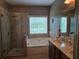 Main bathroom features a shower, soaking tub, double sink vanity and large window for natural light at 106 Trailside Way, Hiram, GA 30141