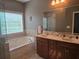 Primary bathroom featuring a soaking tub, double sink vanity, and a large window for natural light at 106 Trailside Way, Hiram, GA 30141