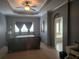 Cozy main bedroom featuring a tray ceiling, fan, gray walls, and ensuite bathroom at 106 Trailside Way, Hiram, GA 30141