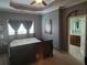 Main bedroom featuring neutral carpet, gray walls, tray ceiling, fan, and ensuite bathroom access at 106 Trailside Way, Hiram, GA 30141