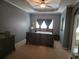 Spacious main bedroom with neutral carpet, gray walls, tray ceiling, and a fan at 106 Trailside Way, Hiram, GA 30141