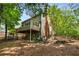 Back exterior view of home with deck, patio, lush landscaping, and mature trees in the backyard at 1061 Polo Club Nw Dr, Marietta, GA 30064