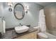 Powder room shows oval mirror above granite vanity with vessel sink and tub-shower combination at 1061 Polo Club Nw Dr, Marietta, GA 30064