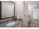 Bathroom featuring granite countertop, oval sink, framed mirror, and a towel ring at 1061 Polo Club Nw Dr, Marietta, GA 30064