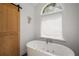 Bright bathroom featuring soaking tub with jets under arched window, and sliding barn door at 1061 Polo Club Nw Dr, Marietta, GA 30064