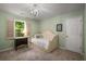 Green bedroom features single bed under chandelier and window with lawn view at 1061 Polo Club Nw Dr, Marietta, GA 30064