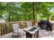 Deck with patio furniture, and a grill surrounded by lush greenery and mature trees at 1061 Polo Club Nw Dr, Marietta, GA 30064