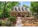 Charming brick home with mature trees, landscaping, and a walkway at 1061 Polo Club Nw Dr, Marietta, GA 30064