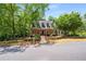 Charming brick home with mature trees, landscaping, and a walkway at 1061 Polo Club Nw Dr, Marietta, GA 30064