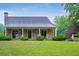Inviting stone house featuring a covered porch with columns, rocking chairs and a well-manicured lawn at 1061 Polo Club Nw Dr, Marietta, GA 30064