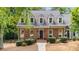 Charming brick home with dormer windows, a welcoming front porch, and lush landscaping at 1061 Polo Club Nw Dr, Marietta, GA 30064