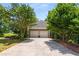 Attached two-car garage with a long driveway, framed by mature trees and landscaping at 1061 Polo Club Nw Dr, Marietta, GA 30064