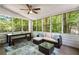 Relaxing sunroom offering wooded views, comfortable wicker seating, and a glass table for outdoor enjoyment at 1061 Polo Club Nw Dr, Marietta, GA 30064