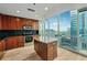 Well-lit kitchen with wooden cabinets, stainless steel appliances, a center island and city views from the sliding glass door at 3324 Peachtree Ne Rd # 1407, Atlanta, GA 30326