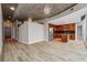 Open-concept living space featuring light hardwood floors, concrete ceilings, modern lighting, and a kitchen view at 3324 Peachtree Ne Rd # 1407, Atlanta, GA 30326