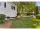 A lush backyard with manicured greenery and a covered parking area for extra vehicles or storage at 3848 Saint Annes Ct, Duluth, GA 30096