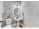 Powder room featuring a pedestal sink, decorative mirror and hardwood floors at 3848 Saint Annes Ct, Duluth, GA 30096