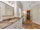 Bathroom featuring a granite countertop, large vanity mirror and decorative floor tiling at 3848 Saint Annes Ct, Duluth, GA 30096