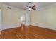 Large bedroom with hardwood floors, neutral walls, a ceiling fan, and a view to an open stairway at 3848 Saint Annes Ct, Duluth, GA 30096