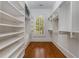 Walk-in closet with built-in shelving and hardwood floors at 3848 Saint Annes Ct, Duluth, GA 30096