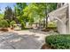 View of a wide driveway featuring a covered parking area and garden bench at 3848 Saint Annes Ct, Duluth, GA 30096