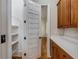 Walk-in pantry with shelving, next to kitchen featuring white countertops and wood cabinets at 3848 Saint Annes Ct, Duluth, GA 30096