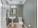 Powder room featuring striped wallpaper, pedestal sink, mirror, and toilet at 3848 Saint Annes Ct, Duluth, GA 30096