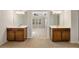 Bright bathroom featuring dual vanities with wood cabinets, tile flooring, and access to main bedroom at 516 Winder Trl, Canton, GA 30114