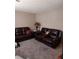 Living room featuring leather couches, neutral walls, and carpet at 636 North Ave # H-10, Jonesboro, GA 30236